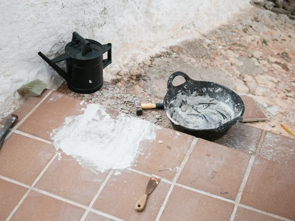 Burkolószerszámok és anyagok kikészítve a padlón